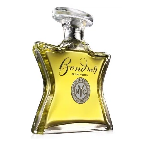 A uniquely shaped glass perfume bottle with golden liquid inside.