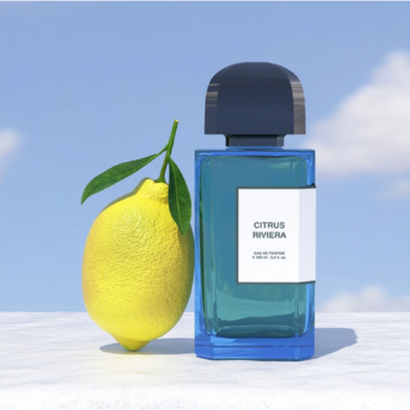 Blue perfume bottle labeled 'Citrus Perfume' next to a fresh lemon.