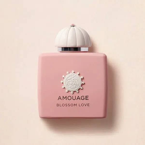A pink Amouage Blossom Love perfume bottle with a white ornate cap.