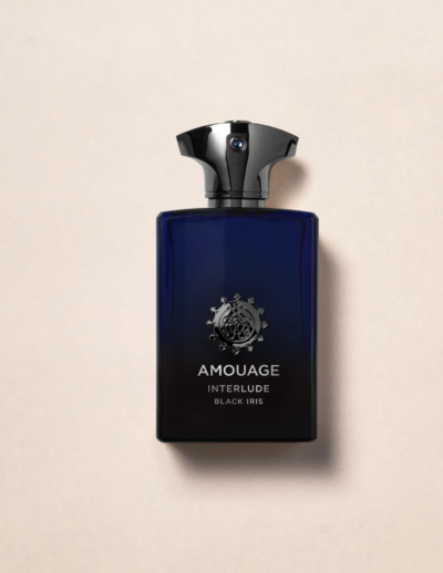 A sleek, dark blue bottle of Amouage perfume with a metallic cap on a beige surface.