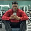 Man in red jacket taking a selfie at the gym.